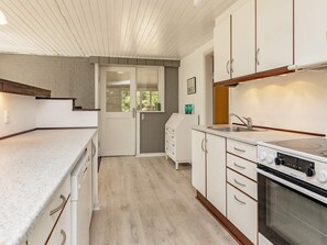 A kitchen with white cabinets, a built-in oven, and a countertop. - 6 Person Holiday Home in Hojslev (Hojslev)