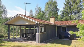 A house with a covered patio, a dining area, and a chimney. - 6 Person Holiday Home in Hojslev (Hojslev)