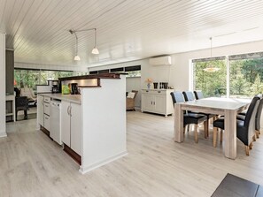 A modern kitchen with white cabinetry, a central island, and pendant lighting. - 6 Person Holiday Home in Hojslev (Hojslev)