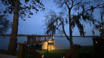 A lakeside cabin with a dock extending into the water, surrounded by trees.