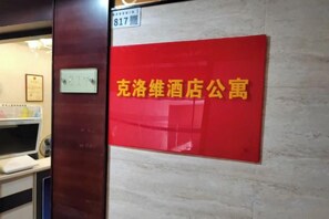 Señal roja con letras amarillas en una pared que indica un baño público.