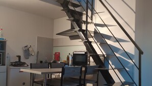 Een moderne keuken met een inbouwtrap die naar een hoger niveau leidt.