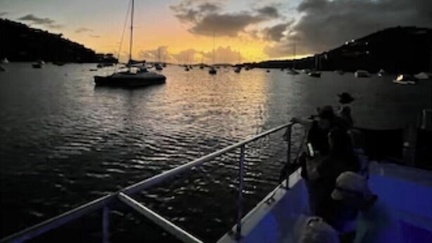Um porto ao pôr do sol com barcos e um cais.