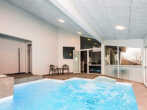 A modern indoor swimming pool with a clear view of the surrounding area, including a seating area and a door leading to another room. - 12 Person Holiday Home in Ebeltoft (Ebeltoft)