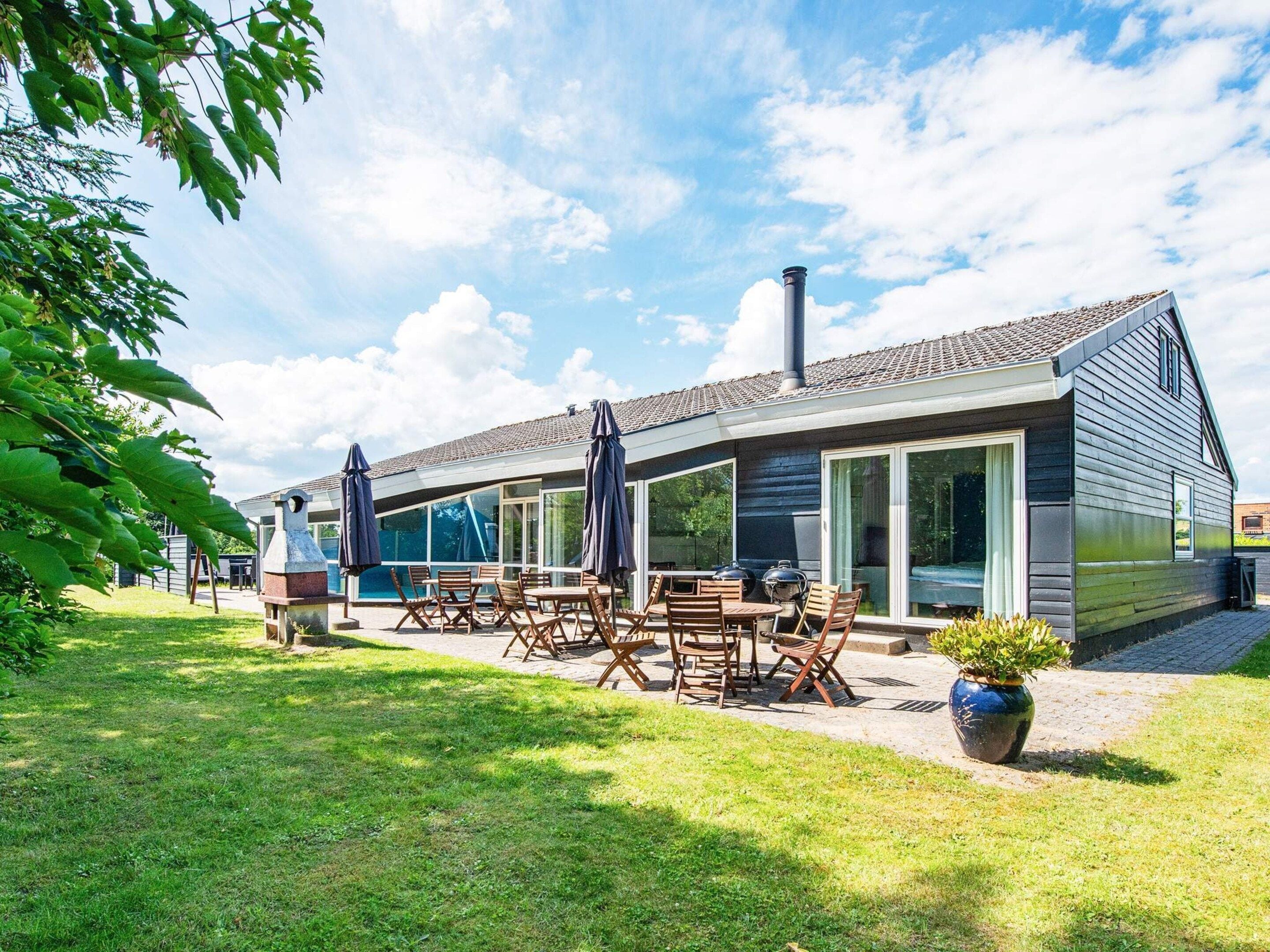 A modern house with a patio, outdoor seating, and a chimney.