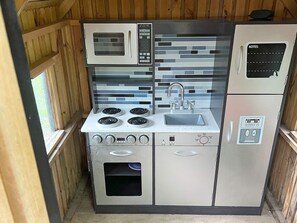 Une cuisine compacte équipée d’un four à micro-ondes, d’une cuisinière, d’un évier et d’un réfrigérateur.