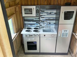 Una cocina compacta con microondas, estufa, fregadero y refrigerador.