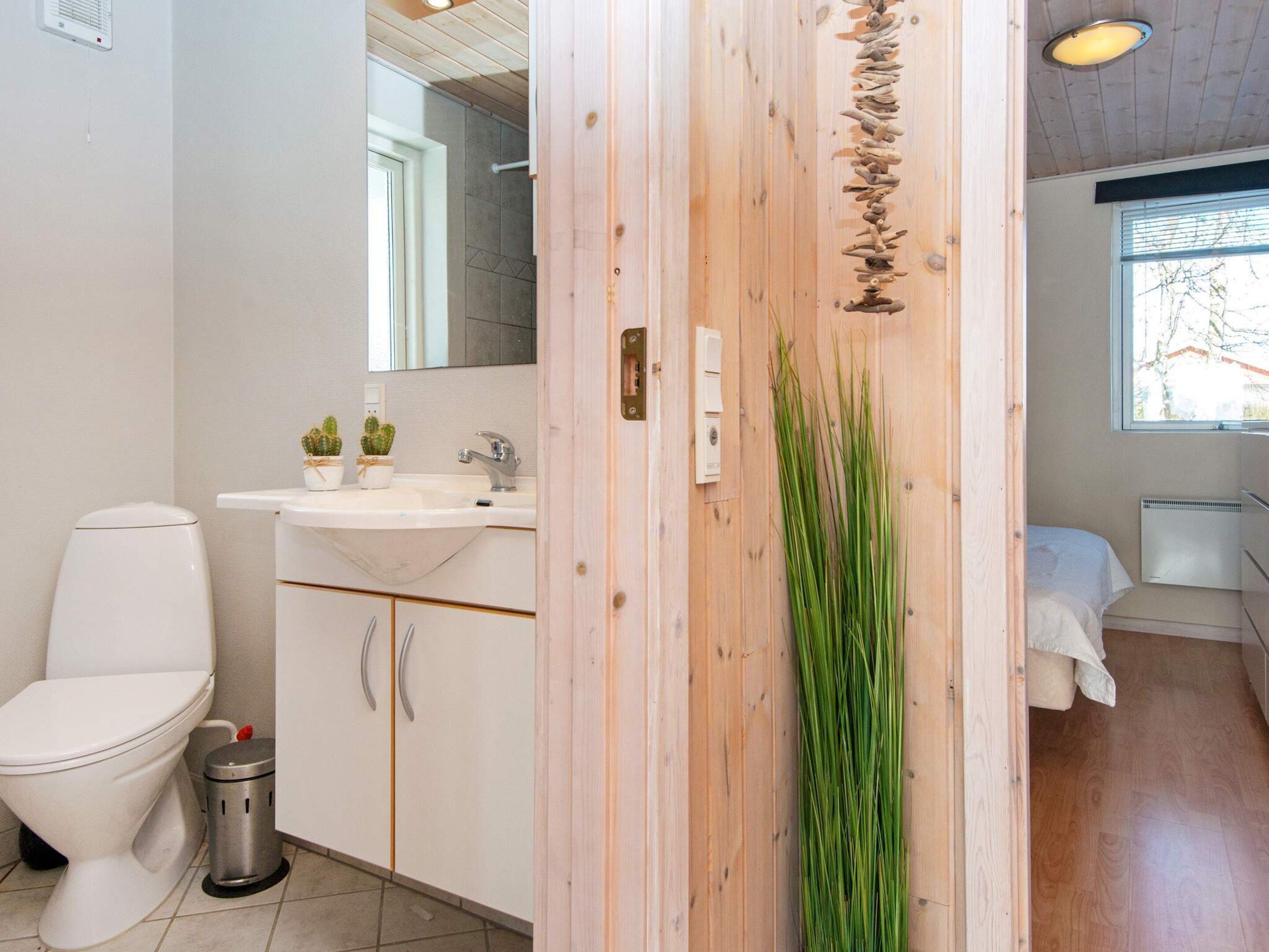 A modern bathroom with a toilet, sink, and mirror.