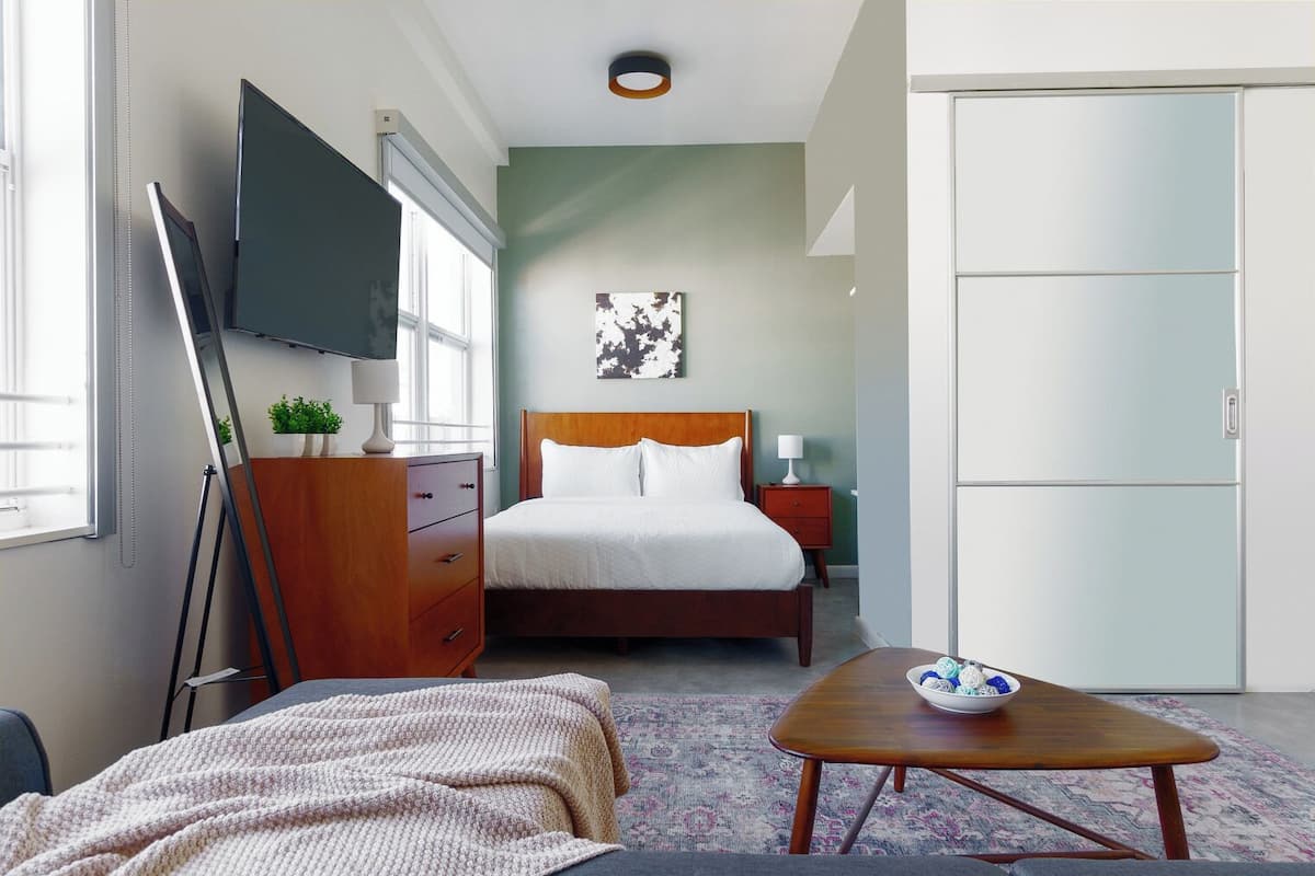 A hotel room with a bed, a TV, a desk, and a wardrobe.
