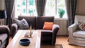 A living room with a sofa, armchair, and a coffee table with decorative items. - 6 Person Holiday Home in Finnas-by Traum (Bomlo)