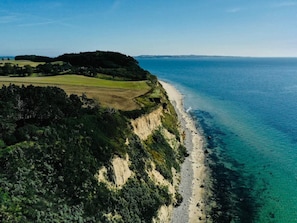 A coastal landscape with a beach, cliffs, and a distant view of the sea. - 6 Person Holiday Home in Knebel (Knebel)