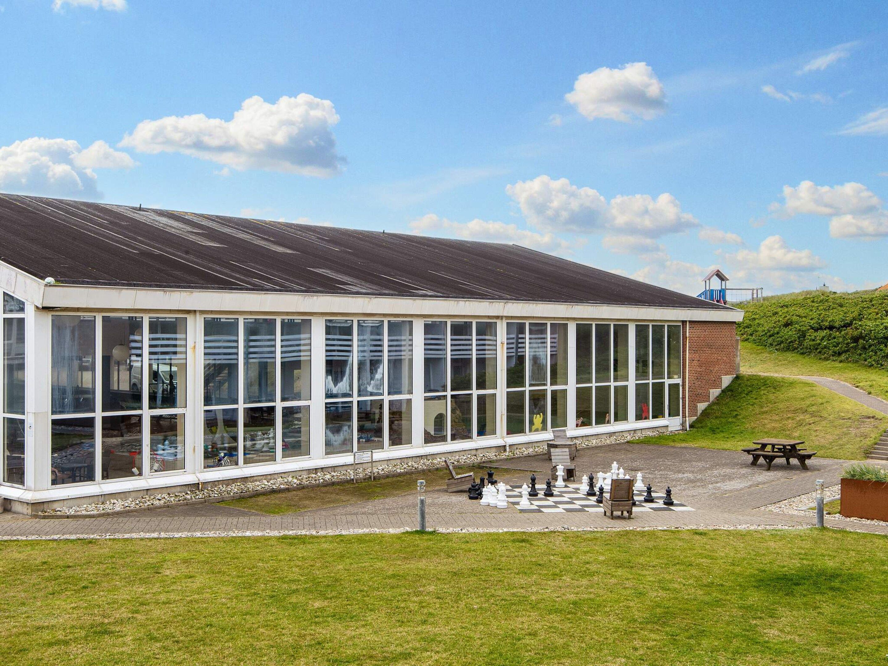 A building with large windows and a covered outdoor area.