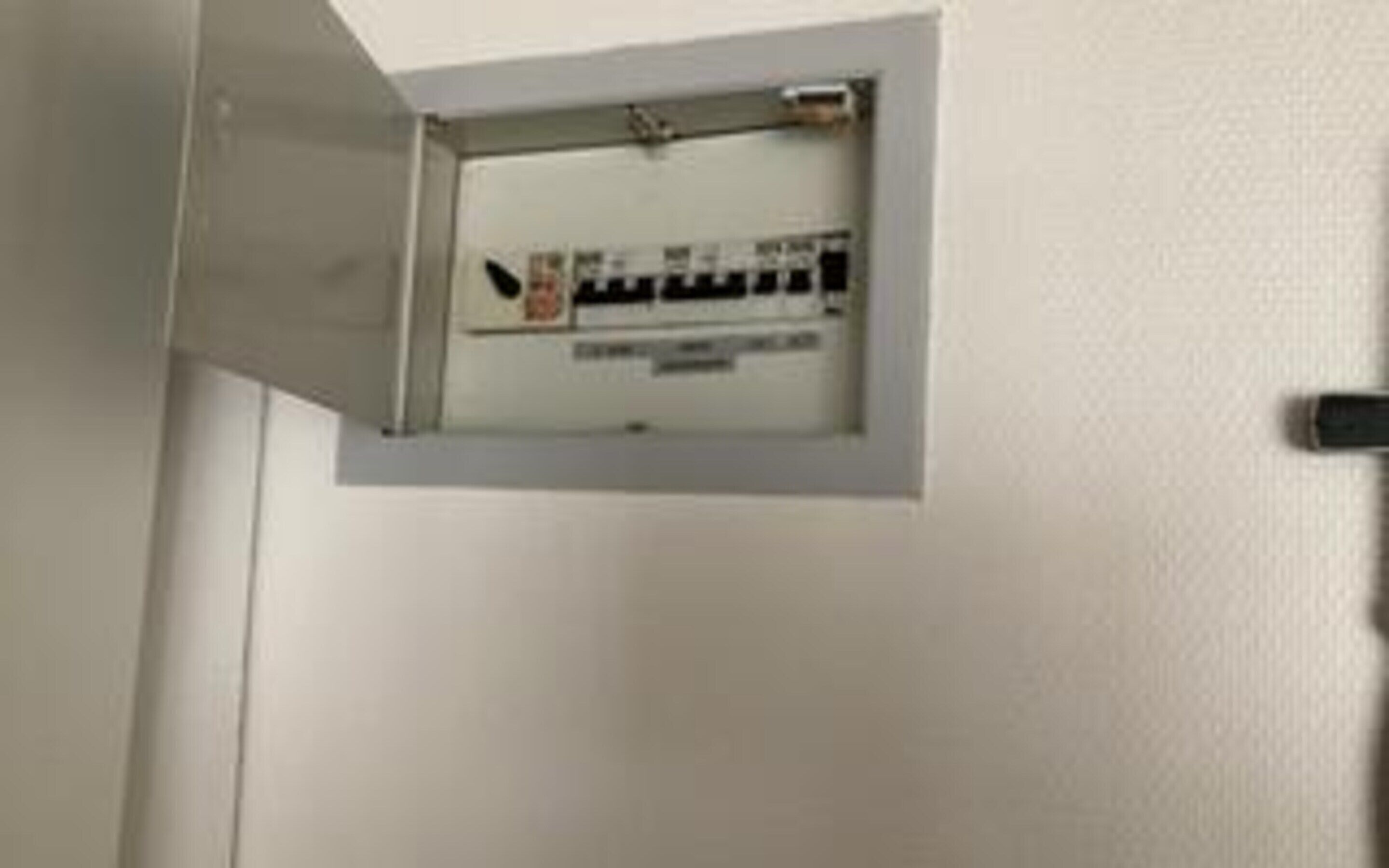 Un plafond blanc avec un panneau électrique encastré.