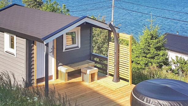 A small cabin with a wooden deck and a hot tub. - 8 Person Holiday Home in Filtvet (Asker)