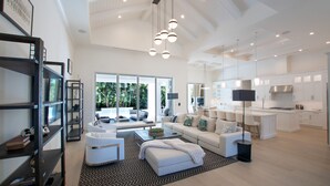 A spacious living area with a large sofa set, a coffee table, and a bookshelf. - Luxury Modern Newly Built House in Naples (Naples)