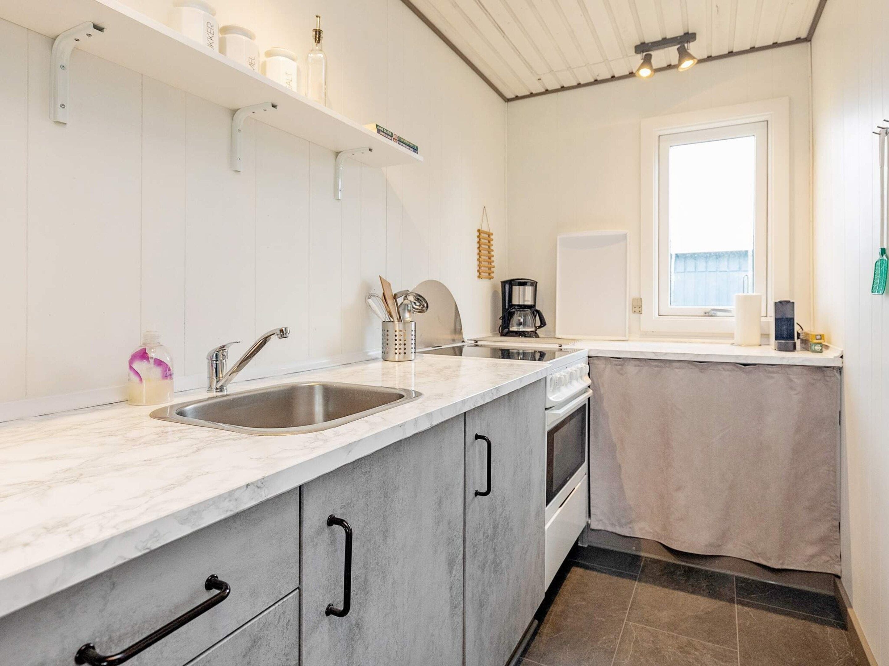 A kitchen with two sinks, a coffee machine, and a window.
