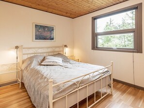 A bedroom with a bed, a window, and a painting on the wall. - 5 Person Holiday Home in Saeby (Sæby)