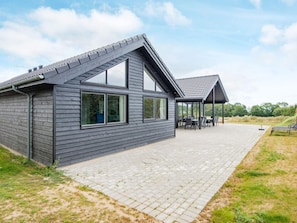 A modern building with a covered patio area and a paved walkway. - 5 Star Holiday Home in Sydals (Sydals)