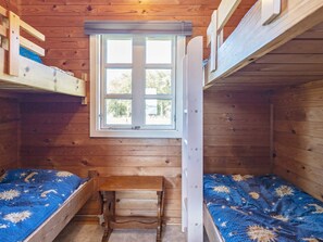 A cabin with two bunk beds, a small wooden table, and a window. - 4 Person Holiday Home in Lokken (Lokken)