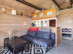 A cozy room with a sofa, a coffee table, and a patterned rug. - 4 Person Holiday Home in Lokken (Lokken)