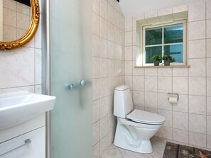 A bathroom with a toilet, sink, and a shower with a glass door. - 8 Person Holiday Home in Toftlund-by Traum (Toftlund)