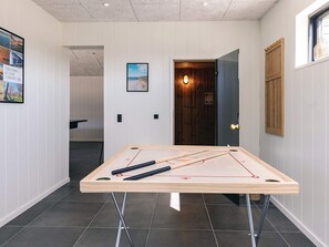 A room with a ping pong table, a wooden door, and a framed picture on the wall. - 8 Person Holiday Home in Jerup-by Traum (Jerup)