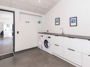 A modern laundry room with a washing machine, a sink, and a countertop. - 8 Person Holiday Home in Jerup-by Traum (Jerup)