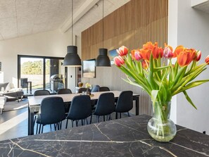 A modern dining area with a marble table, black chairs, and a vase of tulips. - 8 Person Holiday Home in Jerup-by Traum (Jerup)