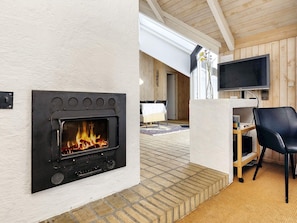 Una sala moderna con chimenea empotrada, televisor de pantalla plana y una zona de estar acogedora.