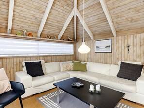 A cozy living room with a sectional sofa, a black coffee table, and a wooden ceiling. - 8 Person Holiday Home in Fjerritslev (Fjerritslev)