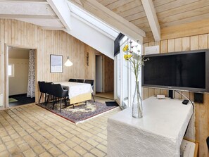 A modern interior with a dining area, a flat-screen TV, and a large window with a view. - 8 Person Holiday Home in Fjerritslev (Fjerritslev)