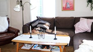 A cozy living room with a wooden coffee table, a brown leather sofa, and a patterned rug. - 5 Person Holiday Home in Fjaras (Fjärås)