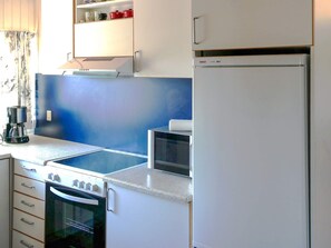 A kitchen with a stove, oven, refrigerator, and a coffee maker. - 6 Person Holiday Home in Saltum (Saltum)