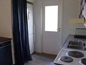 A compact kitchen with a refrigerator, a window, and a sink. - 5 Person Holiday Home in Traslovslage (Träslövsläge)