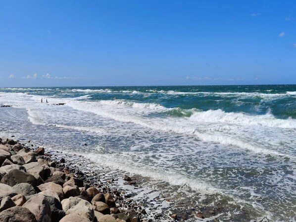 A rocky beach with waves crashing onto the shore.