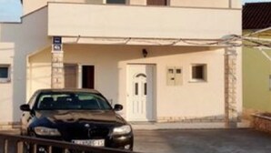 A two-story building with a car parked in front. - Apartment Mijatovic - One Bedroom Apartment with Terrace (Vodice)