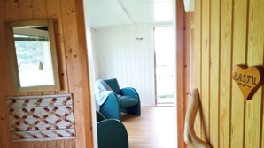 A wooden interior with a door leading to a room with a blue chair and a heart-shaped decoration with the name "Bastil". - 5 Person Holiday Home in Lulea-by Traum (Luleå)