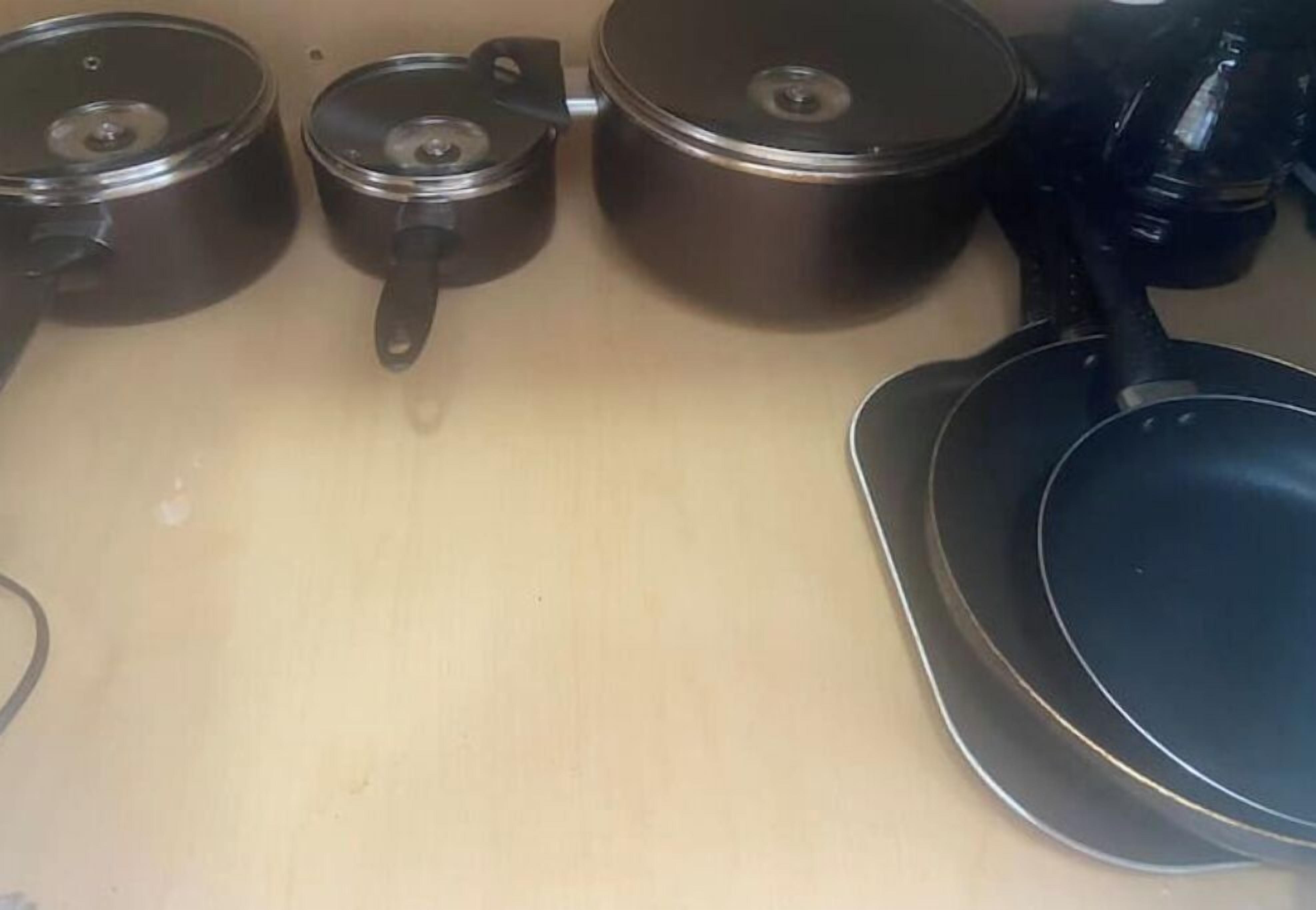 Una encimera de cocina con tres ollas y una sartén.