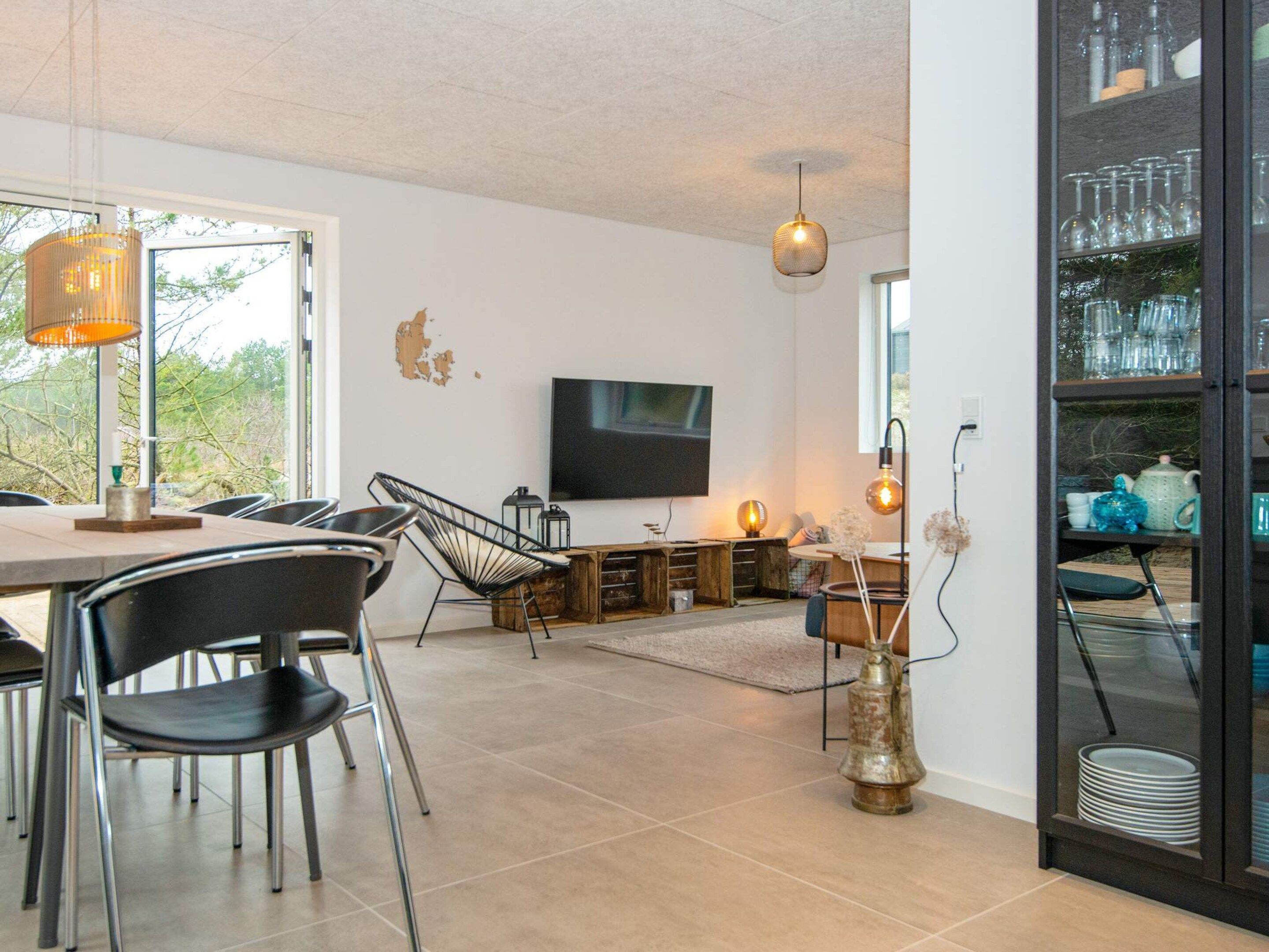 Ein moderner Essbereich mit Fernseher, Stühlen und einem Tisch.
