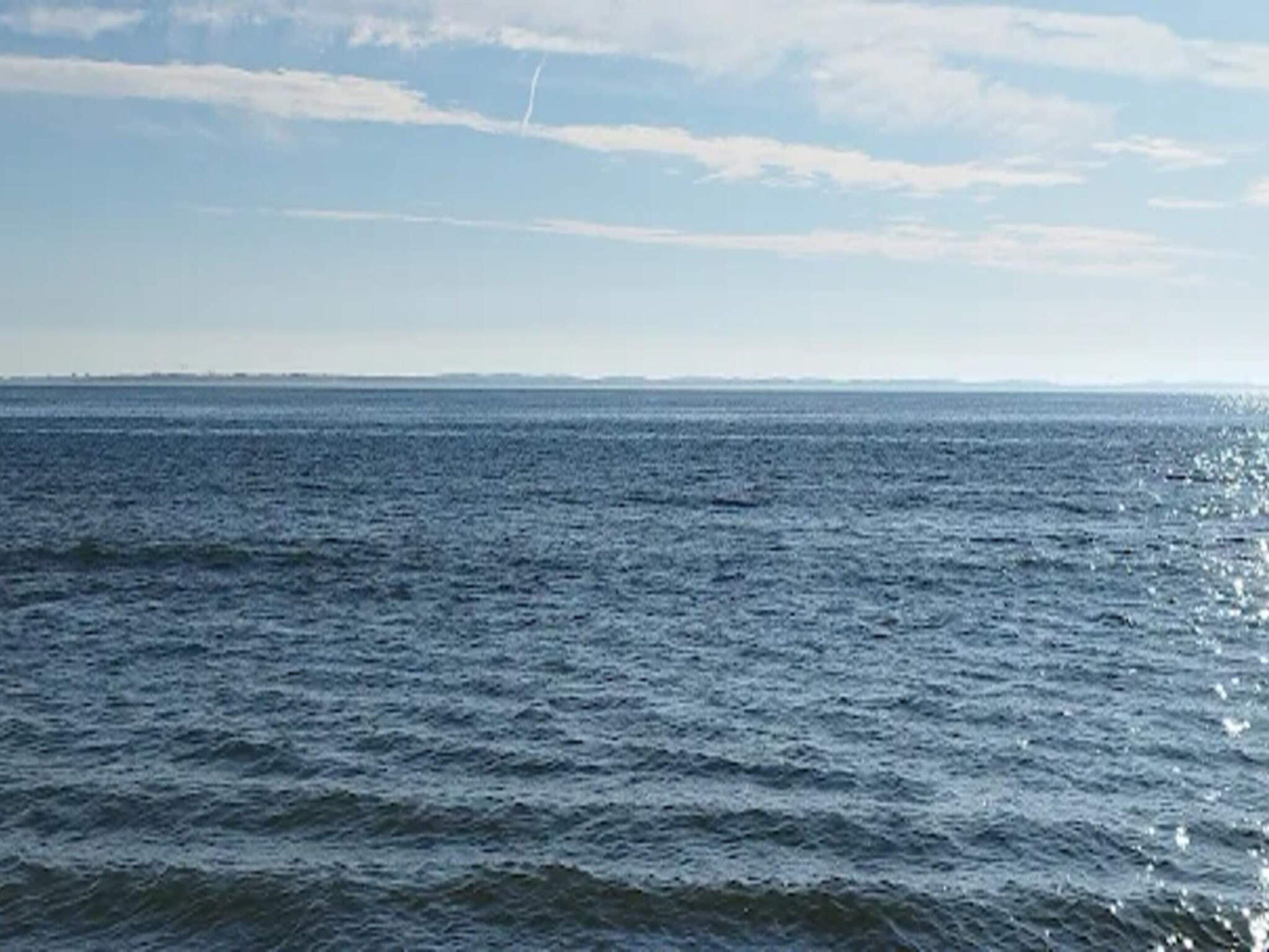 Une vue d'une vaste étendue d'eau, avec une côte lointaine.