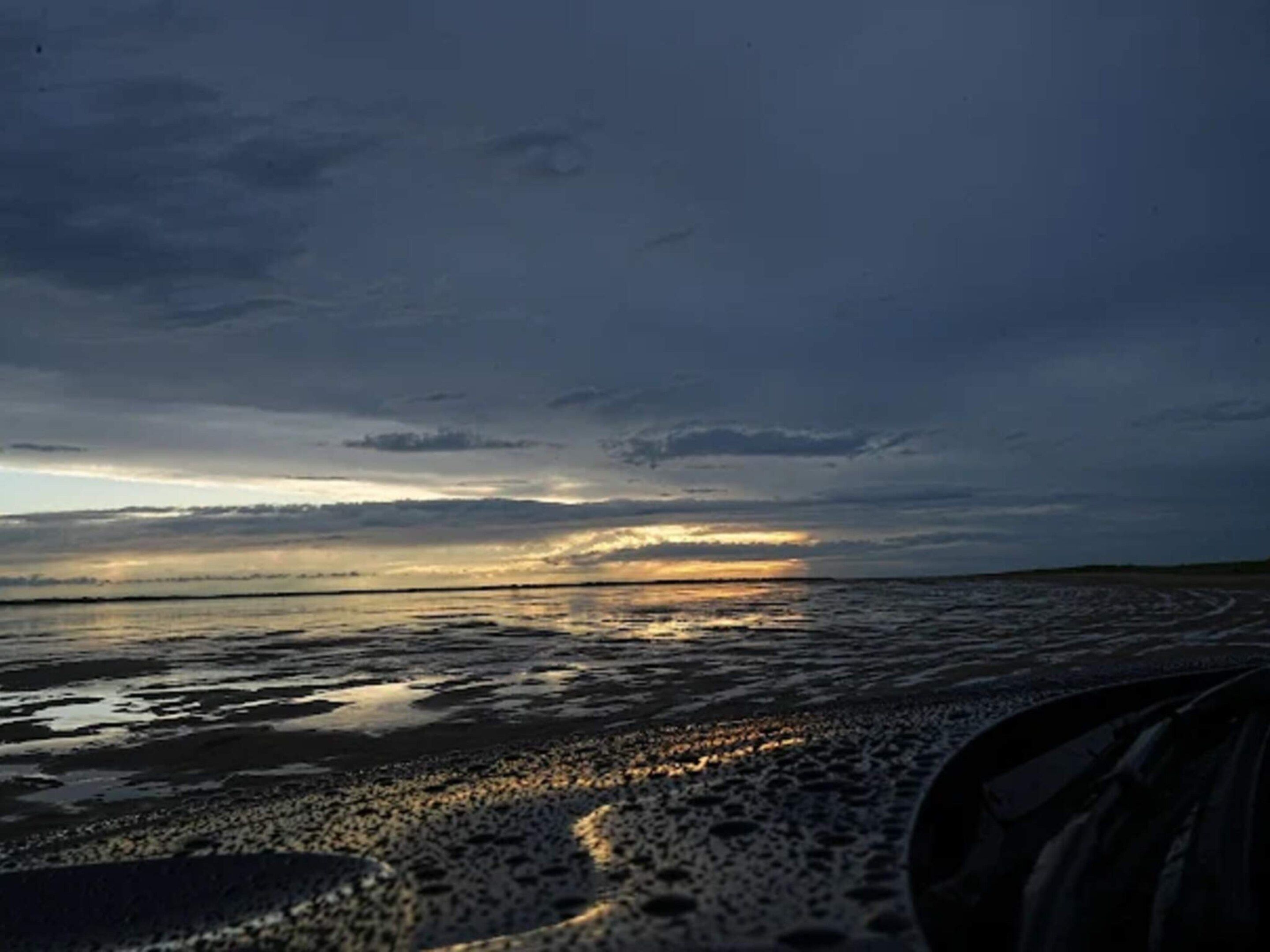 Een strandscène met een zonsondergang.