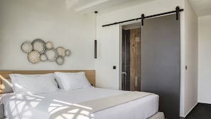Un dormitorio moderno con una cama grande, cabecera de madera, lámpara de pared y armario con puerta corrediza.