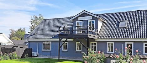 A two-story house with a balcony and a sign reading 'Strandgaarden.'