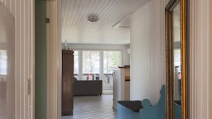 A hallway with a tiled floor, a blue bench, and a large mirror. - 6 Person Holiday Home in Sjaellands Odde-by Traum (Sjællands Odde)