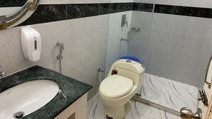Ein Badezimmer mit Marmorwaschbecken, Toilette und Dusche.