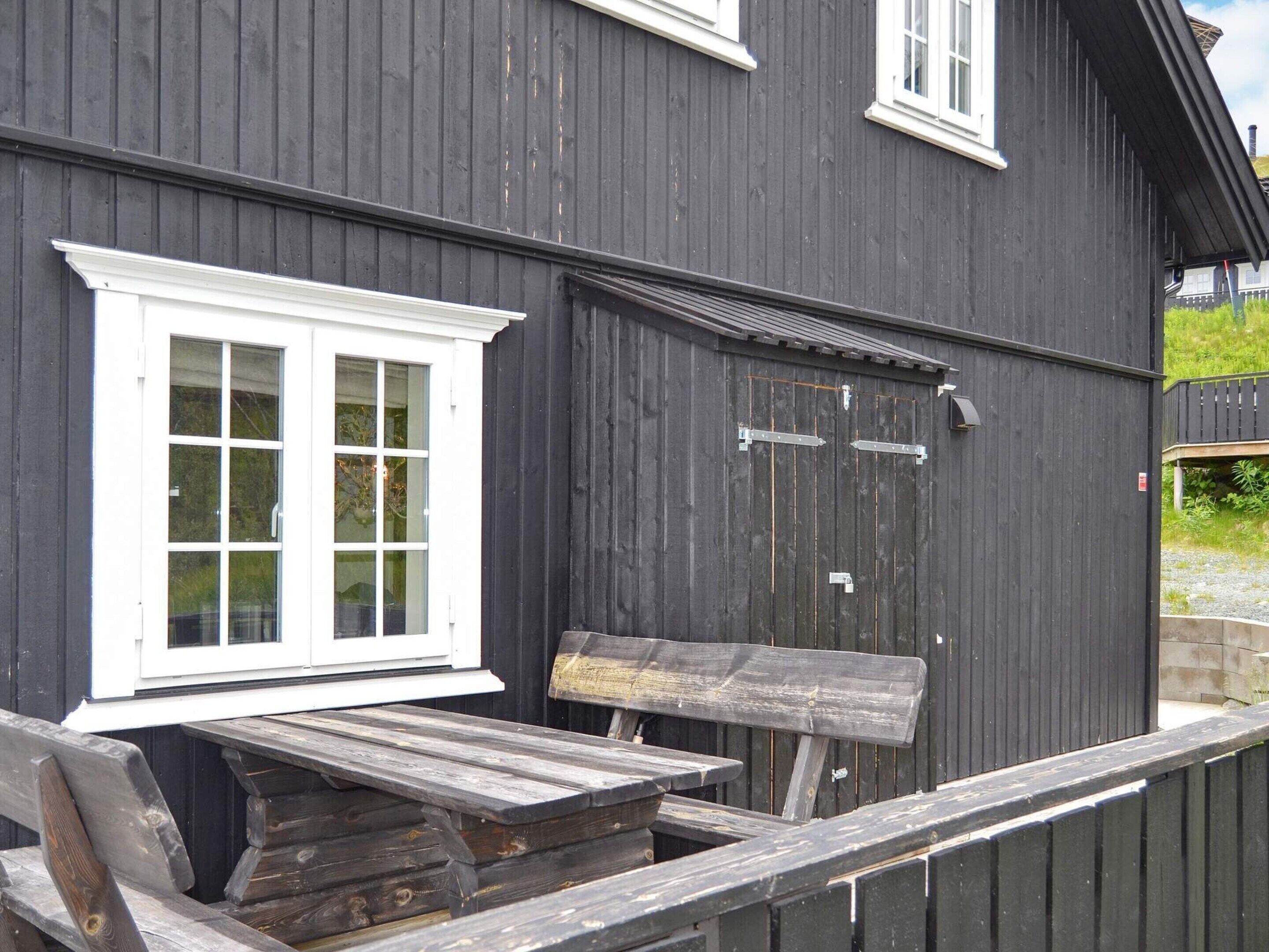 A dark wooden building with a white-framed window and a closed door.