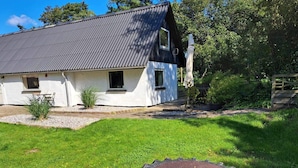 A white house with a grey roof, a small garden, and a large tire swing. - 6 Person Holiday Home in Kolind (Kolind)