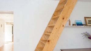 A wooden ladder against a white wall, a wooden cabinet, and a hallway leading to another room. - 6 Person Holiday Home in Kolind (Kolind)