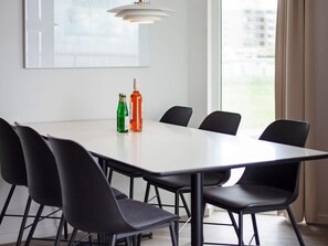 A conference room with a white table, black chairs, and two bottles on the table. - 5 Star Holiday Home in Wendtorf (Wendtorf)