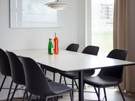 Un salón de conferencias con una mesa blanca, sillas negras y dos botellas sobre la mesa.